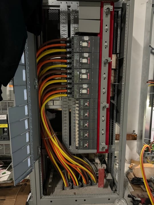 Commercial panelboard with switchgear and breakers wired up with high-amperage feeders.