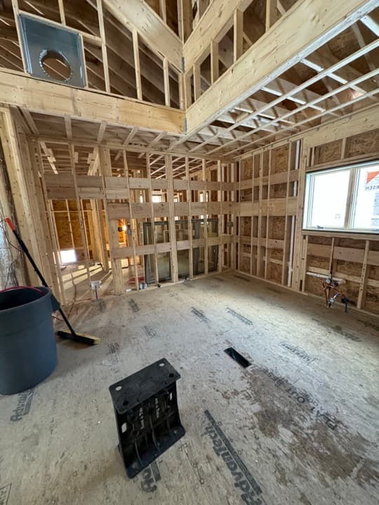 High-ceiling new-construction framing with skylights and rough-in cable runs along the joists.