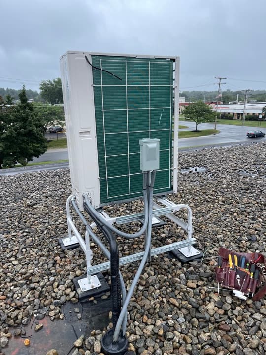 Pad-mounted commercial transformer with sweeping conduit risers and feeders coming up from underground service.